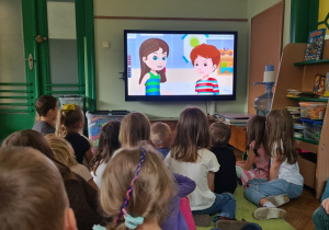 Dzieci oglądają film pt. "Skąd się biorą produkty ekologiczne"