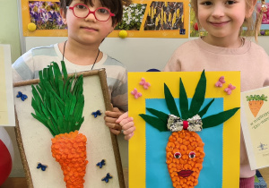 Dzieci z przedszkola pokazujące prace plastyczne na konkurs Eko - marchewka.
