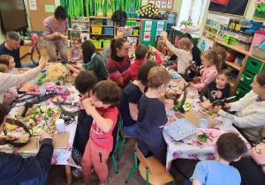 Dzieci z rodzicami podczas warsztatów wielkanocnych.