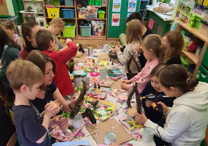 Dzieci z rodzicami podczas warsztatów wielkanocnych.