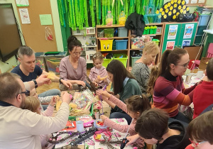 Dzieci z rodzicami podczas warsztatów wielkanocnych.