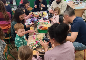 Dzieci z rodzicami podczas warsztatów wielkanocnych.