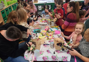 Dzieci z rodzicami podczas warsztatów wielkanocnych.