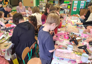 Dzieci z rodzicami podczas warsztatów wielkanocnych.