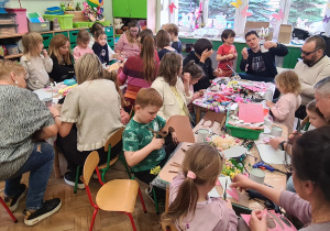 Dzieci z rodzicami podczas warsztatów wielkanocnych.