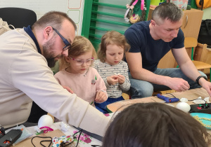 Dzieci z rodzicami podczas warsztatów wielkanocnych.