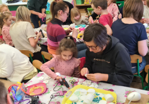 Dzieci z rodzicami podczas warsztatów wielkanocnych.