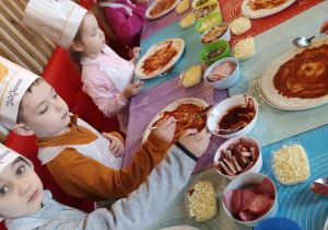 Dzieci z grupy II Żabki podczas tworzenia samodzielnie pizzy
