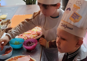Dzieci z grupy II Żabki podczas tworzenia samodzielnie pizzy