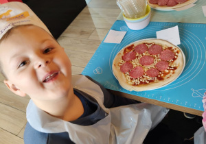 Dzieci z grupy II Żabki podczas tworzenia samodzielnie pizzy