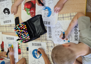 Dzieci kolorują obrazek z okazji Międzynarodowego Dnia Kropki