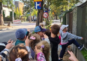 Dzieci z grupy III Jagody podczas spaceru w poszukiwaniu znaków drogowych